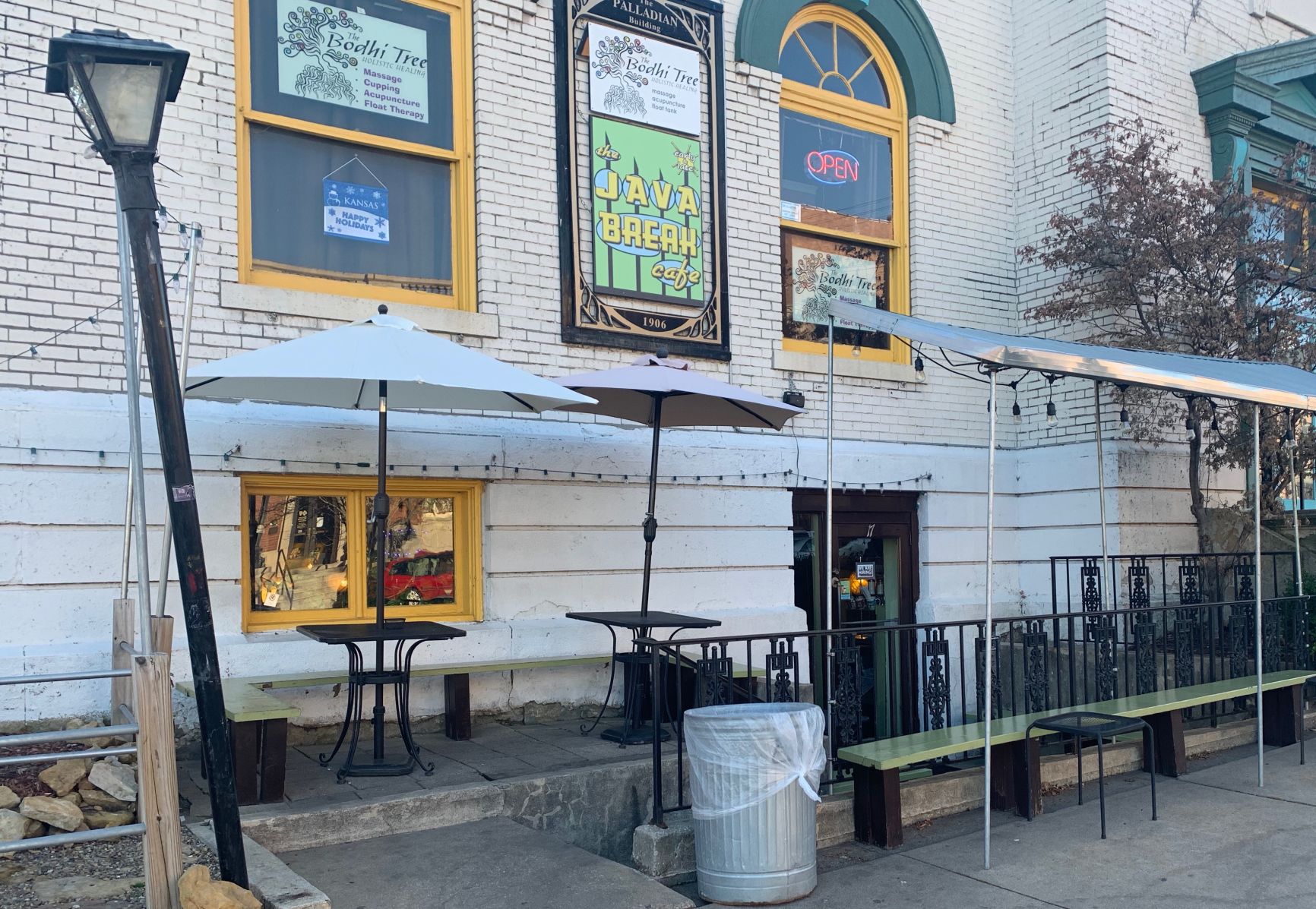 The exterior of the Java Break coffee shop has two tables and a bench